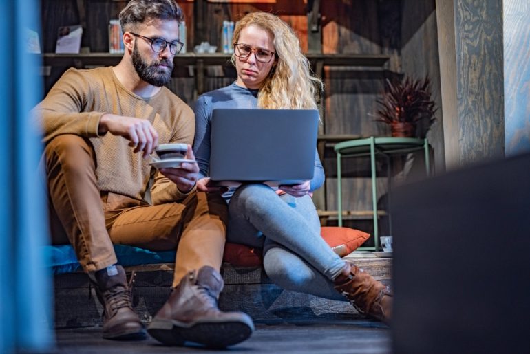 to unge akademikere diskuterer over en laptop